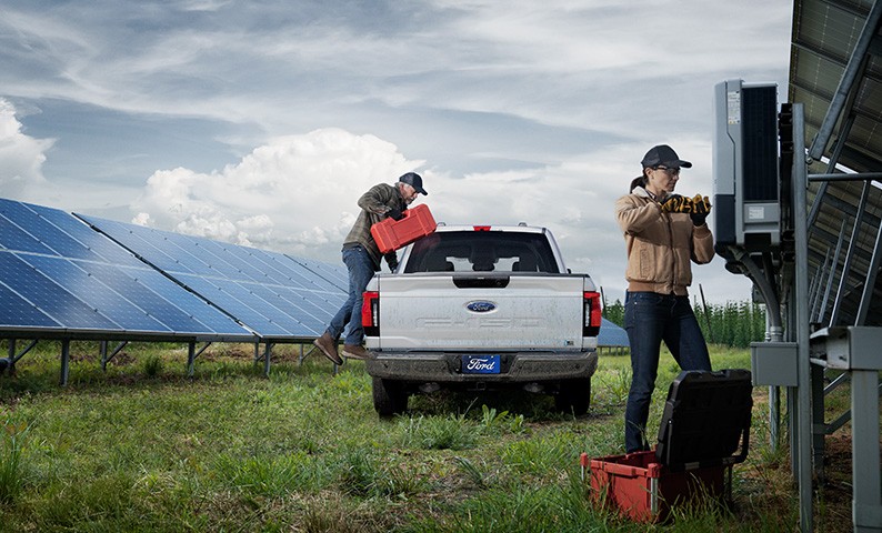 Two technicians are working to fix solar panels