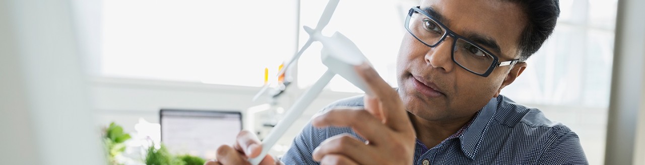Image of man looking at a wind turbine model