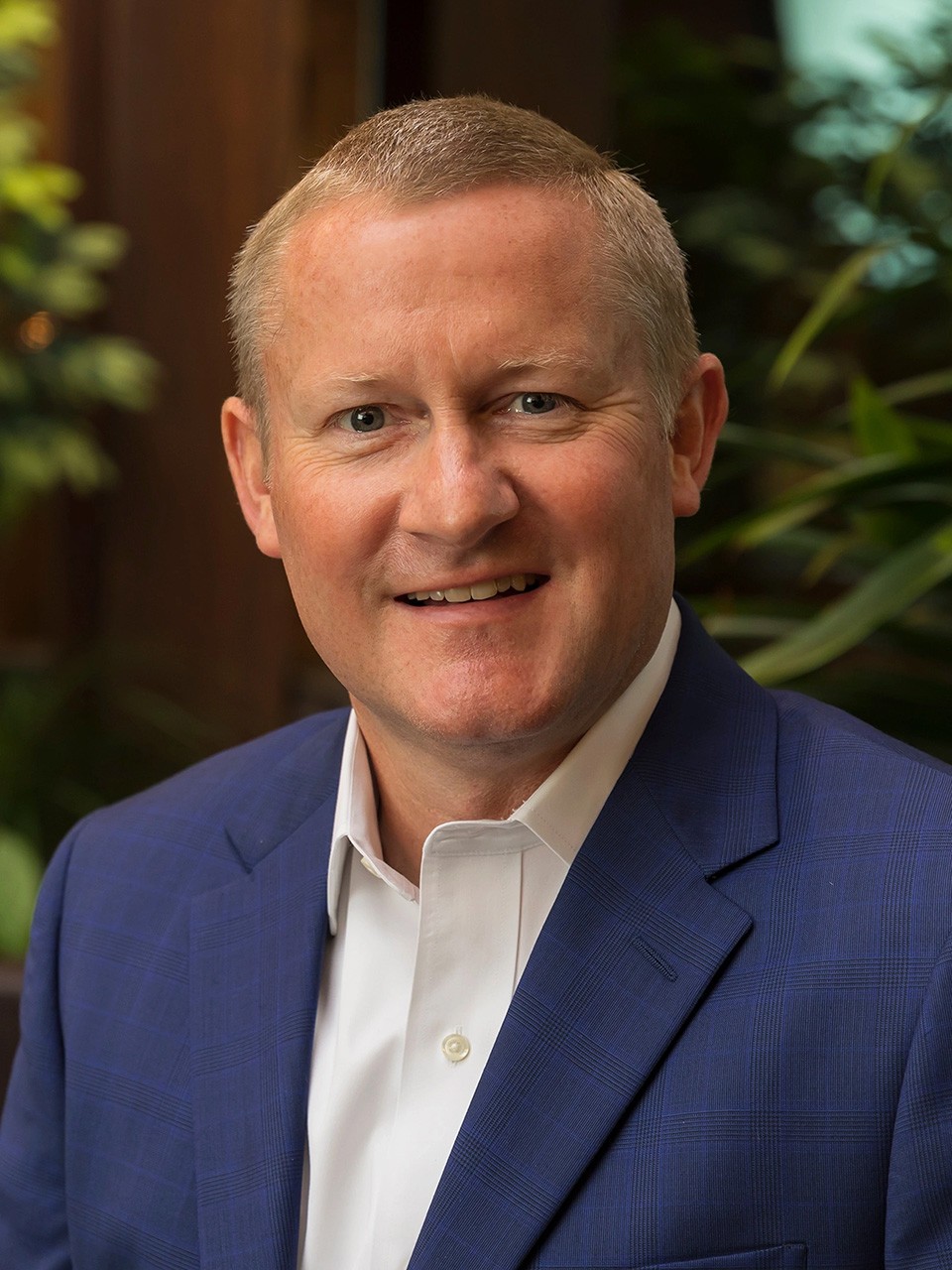John May, seated in a lobby, smiles to camera