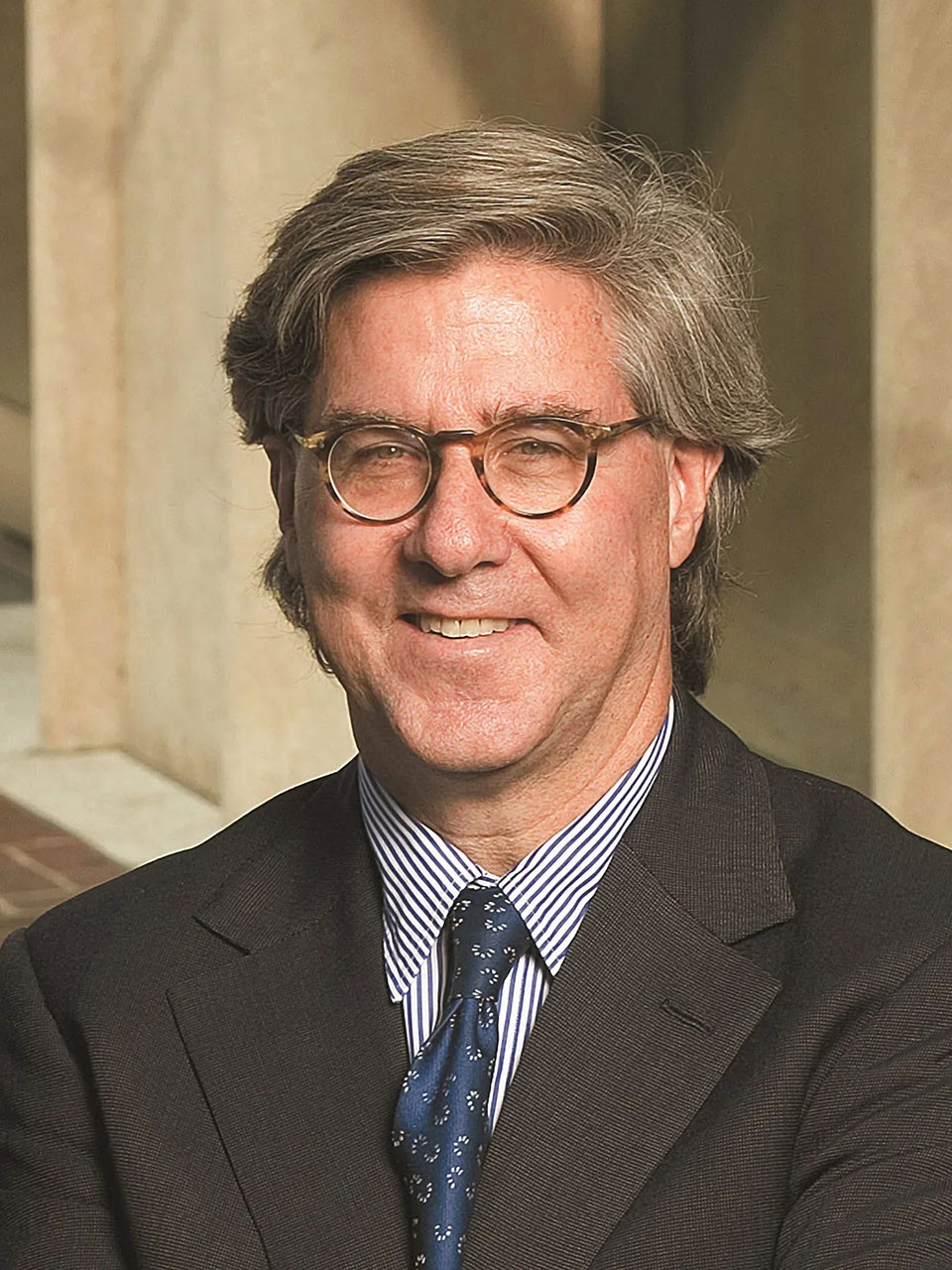 John Thornton, standing outside a building, smiles to camera