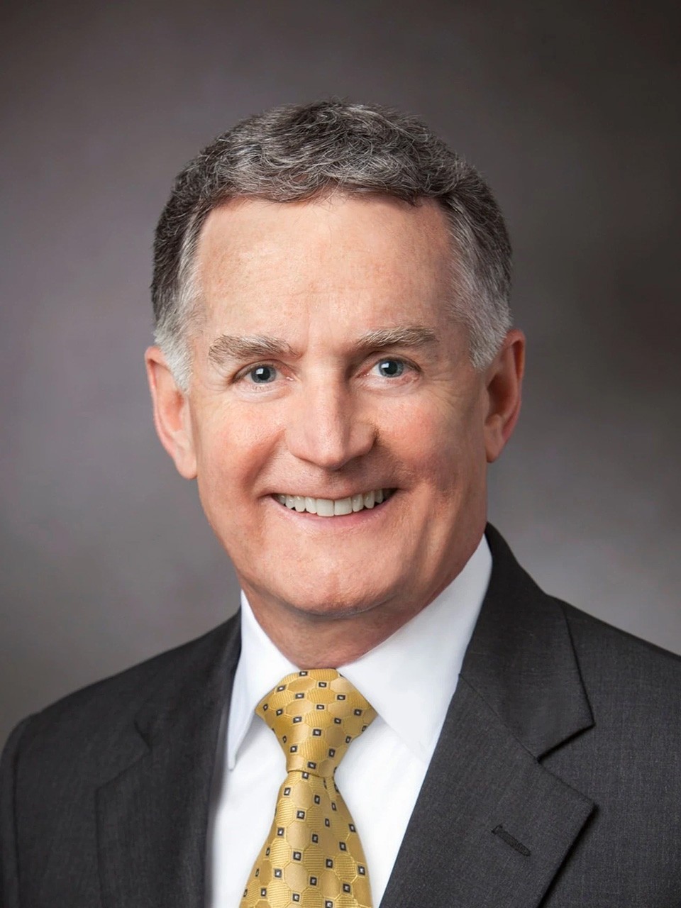John Veihmeyer, in a studio, smiles to camera