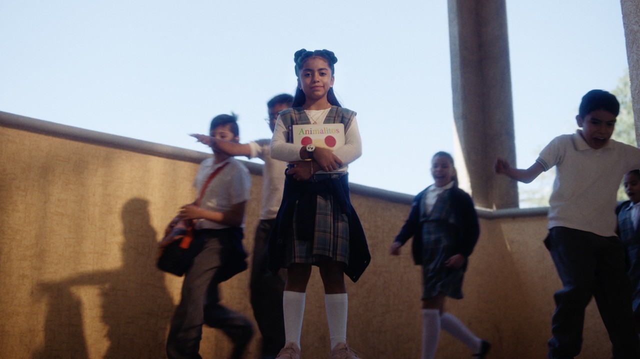 Little kid holding a book at schools stairs