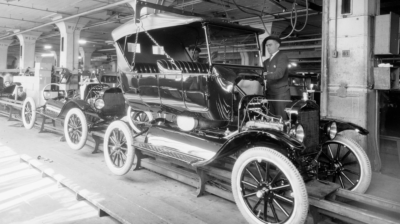 Black and white photo of an automobile in an assembly line