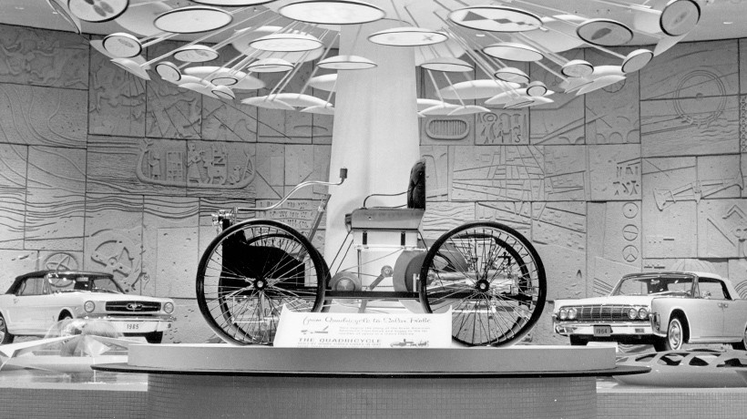 A black and white photo of a Quadricycle on a display platform