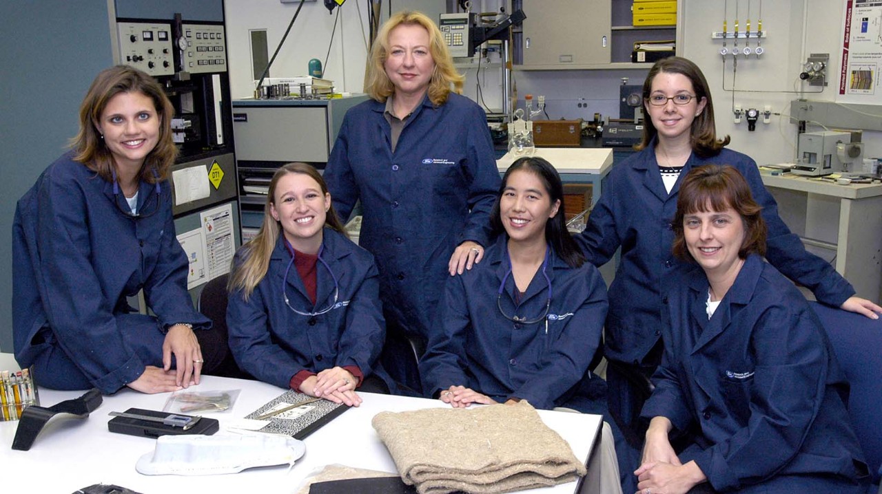 A group of women scientists are sitting around a work area