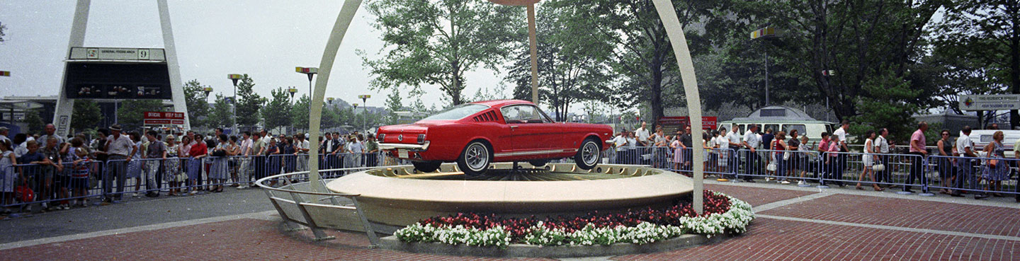A red 1965 Mustang car on a display platform