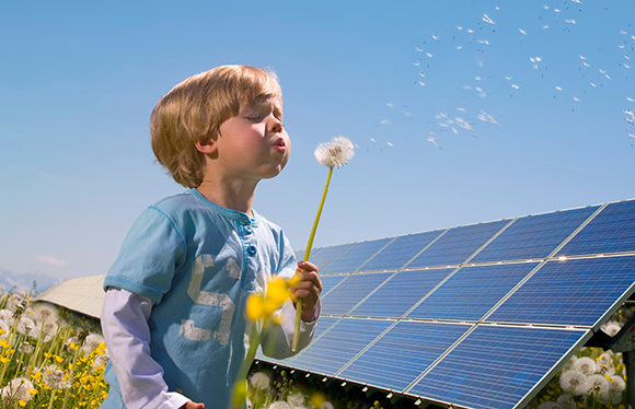 Boy blowing on a flower