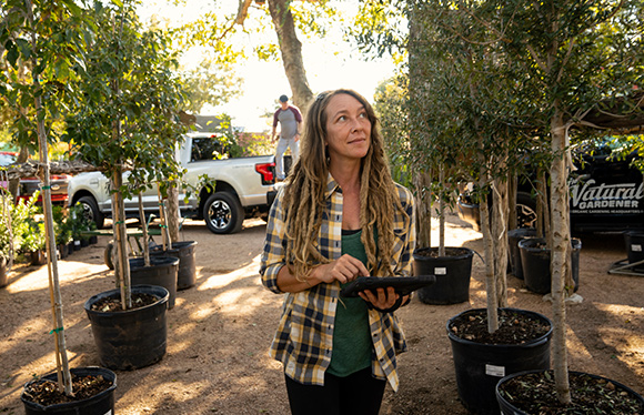 Woman holding tablet at garden nursery