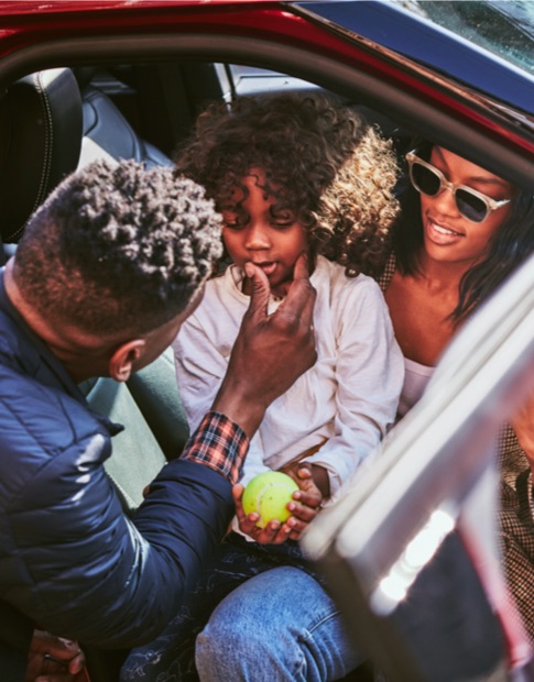 Mother, father and young son enjoying time together in the front seats of a Ford vehicle