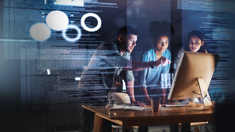 Young people collaborating around a computer screen