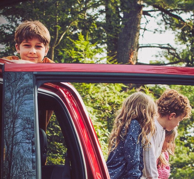 Young friends enjoying time outdoors together around a parked Ford vehicle