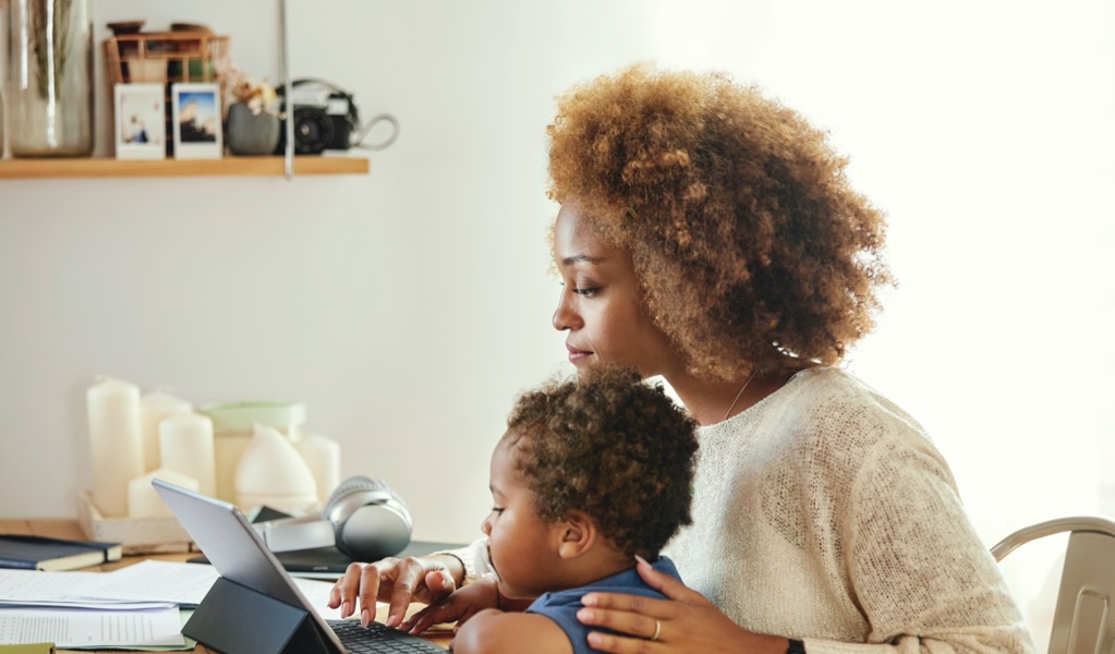 Mother working from home with infant on her lap