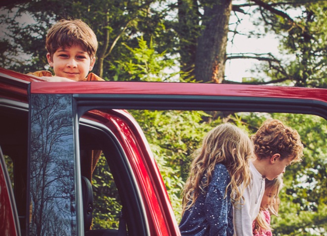 Young friends enjoying time outdoors together around a parked Ford vehicle