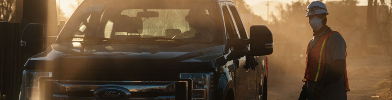 A construction worker is by a Ford truck